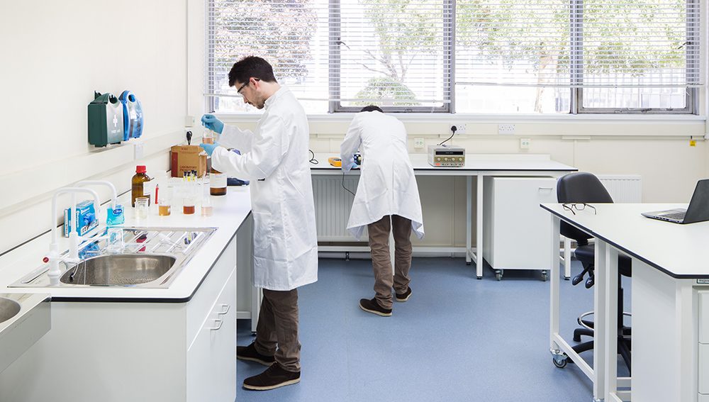 Scientists pouring liquids with precision in lab space at Culham Innovation centre